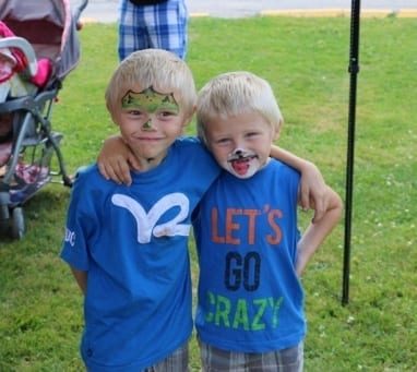 two children with arms around each other and painted faces