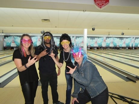 Skyline employees dress up in 80s hairband wigs for theme bowling