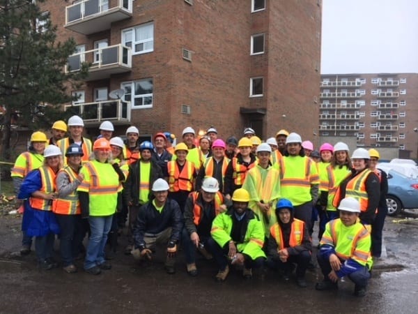 Group photo of over thirty people in hard hats and construction shirts