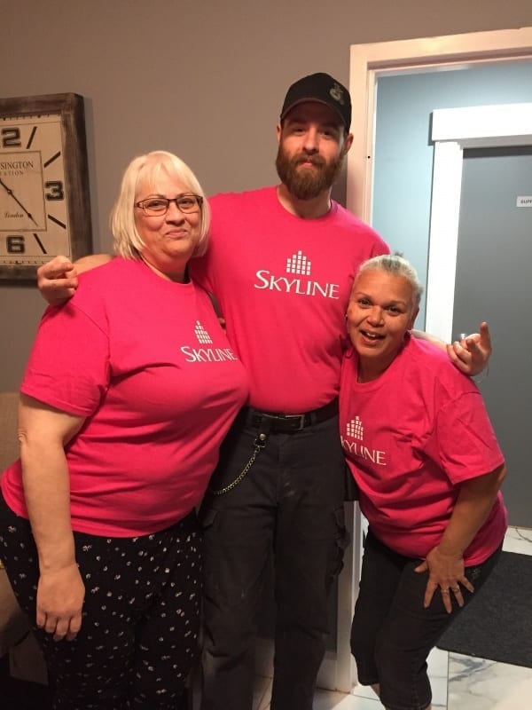 Three Skyline staff in Nova Scotia wear pink shirts