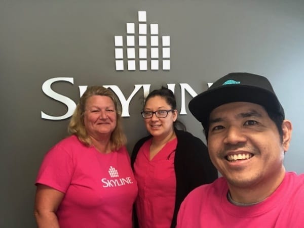 Three Skyline staff in Alberta wear pink shirts