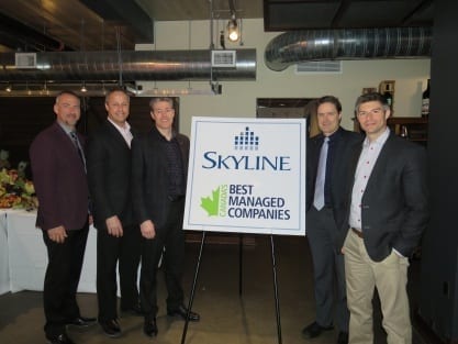 Skyline Owners and executives pose beside a Best Managed Companies banner