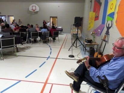 Man plays the guitar to attendees of the event