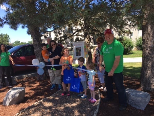 Resident manager Bill is shown cutting the ribbon at the new lending library