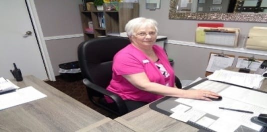 Mave, the Resident Manager Winner, sitting at a desk working