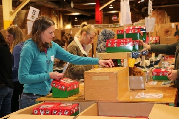 Two Skyline Employees pack shoe boxes for children