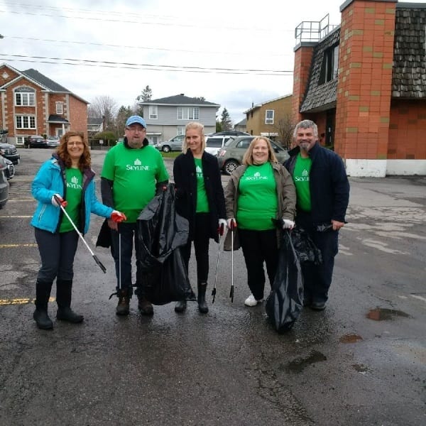 Five people pose after collecting garbage for earth day