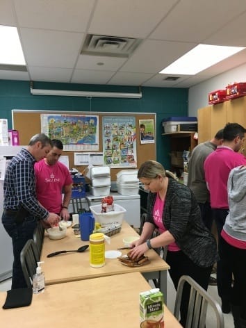 Three Skyliners prepare food at Gateway Public School