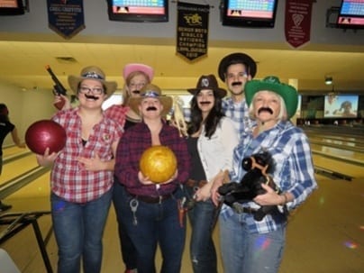 Six Skyline employees dress in cowboy outfits for theme bowling