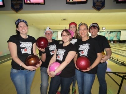 Six Skyline employees dress in rock and bowl outfits for theme bowling