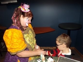 Cleo the Clown paints a child's arm