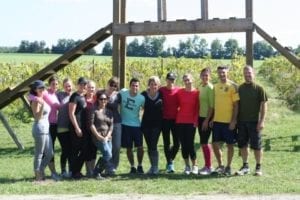 A group of fourteen Skyliners pose in front of an obstacle course they built out of wood