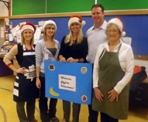 Five Skyline Wealth Management employees pose in Santa hats after volunteering