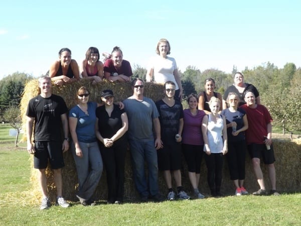 Fifteen Skyline employees pose by bales of hay