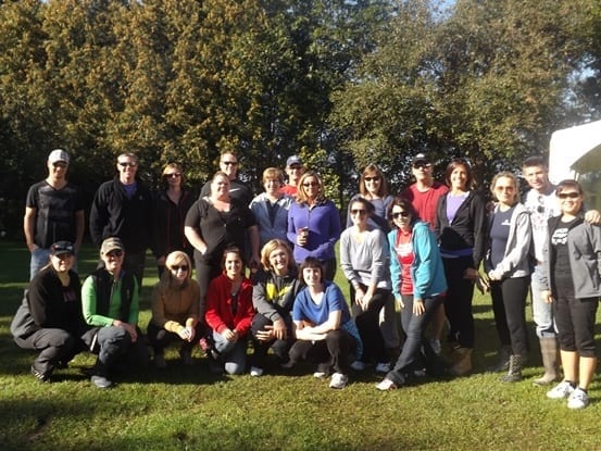 Twenty-two Skyline employees pose on a lawn