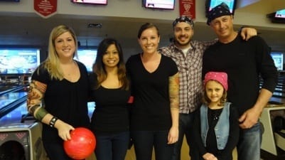 Six Skyliners dress in black with fake tattoos for theme charity bowling